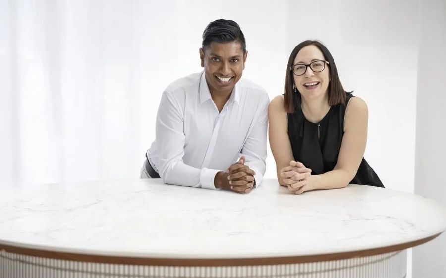Denver and Sam Naidoo seated at a white table